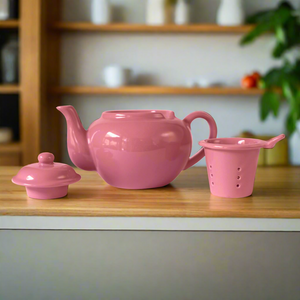 pink ceramic teapot with infuser